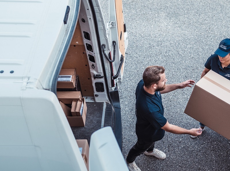 coworkers rushing to load packages in a delivery van